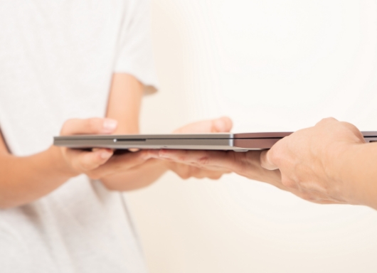 ノートパソコンを手渡す様子