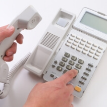 デスクに置かれた白いビジネスホンの電話機